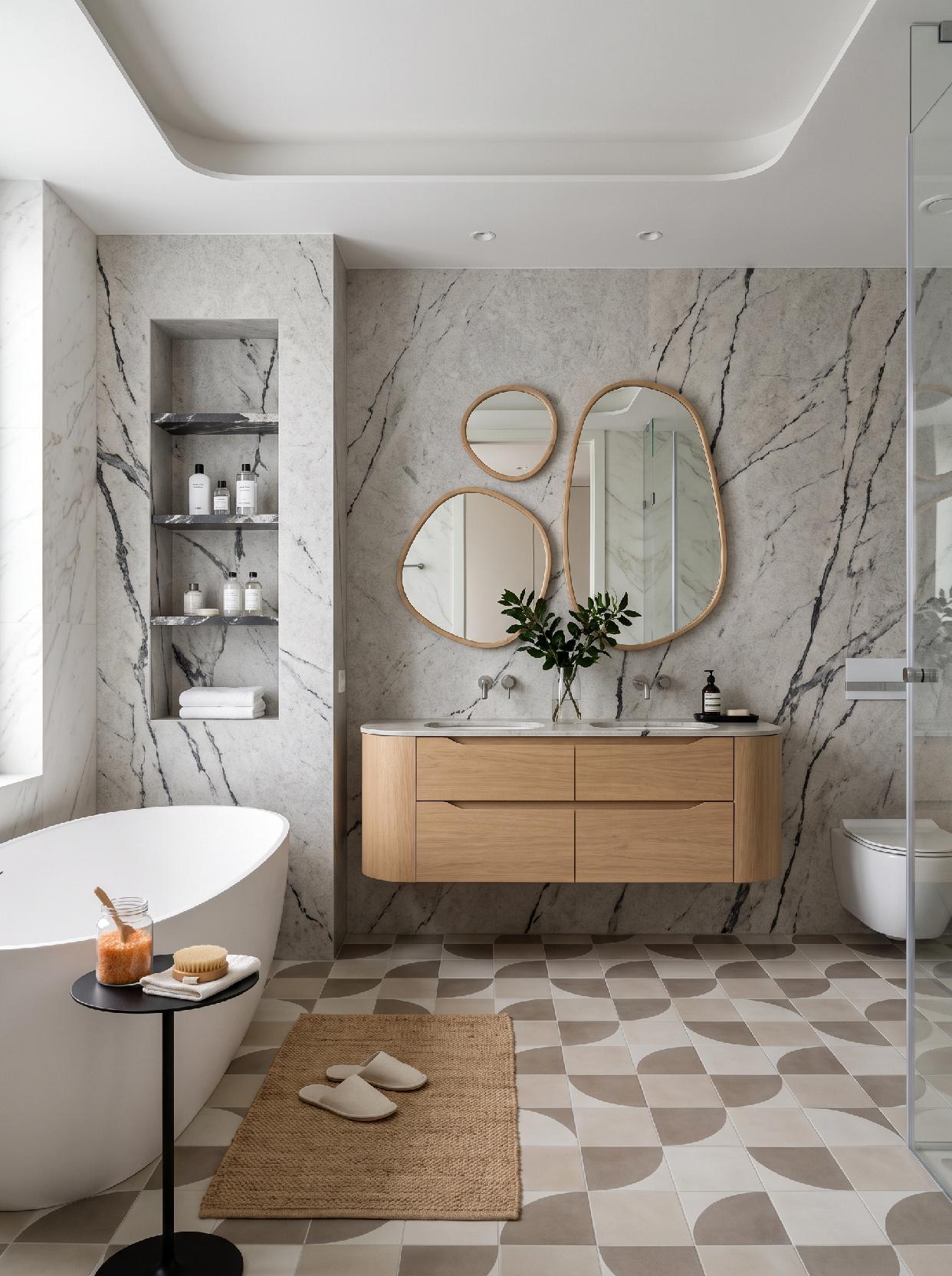 A photograph of a luxurious organic modern bathroom with dramatic natural stone, warm wood, and geometric patt