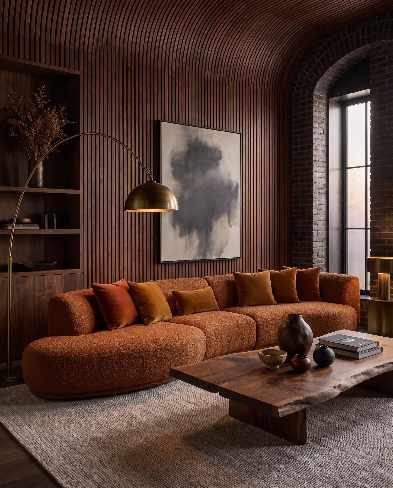 A photograph of a warm and moody contemporary living room with organic forms and rich textures, captured at ey